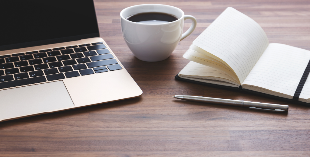 Laptop sitting on desk with coffee